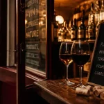 Bar à vin quartier paris : comptoir de cave, verres et ardoise dans une rue secondaire