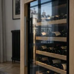 Cave à vin climatisée à Paris, bouteilles stables malgré chauffage, encastrée en niche.