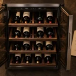 Cave à vin 24 bouteilles : portes en verre et bouteilles alignées, thermomètre et carnet
